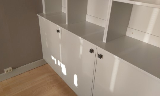 platsbyggd grå bokhylla med bänkskåp för dold förvaring